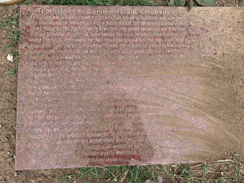 [Photograph of a cut red granite stone with
white lettering, covered with dirt, commemorating a dog named "Ke Ruo Xuan,"
with a text in English, reproduced below.]