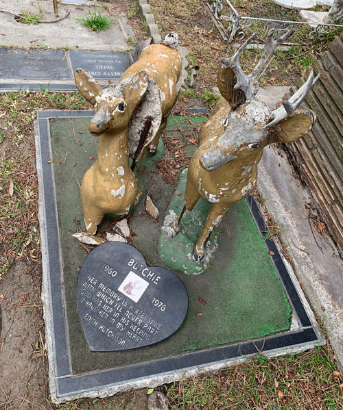 [Photograph of a large painted concrete
monument in the form of two deer, one of which is broken, exposing rusting
rebar; heart-shaped memorial at its base commemorates a monkey named "Butchie,"
1960-1976, with a photograph bleached white by the sun.]