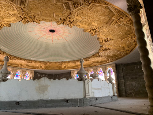 [View of shabby area behind
uppermost decorations that are visible from the public areas of the tower,
directly underneat the top of the dome; a wire hangs from a hole in its
center.]
