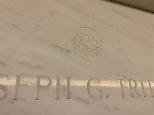 [Marble slab cut with a name
under an image of a chain with three links over the letters "FLT."]