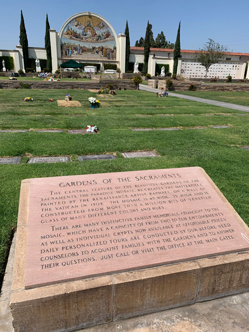 [View of grave-lined lawn toward
an enormous mosaic, described by text on stone tablet in foreground, transcribed
below.]