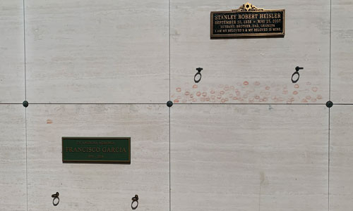 [Stone wall with graves, one of
which is stained with lipstick.]