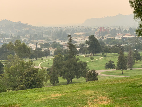 [View of rolling green hills with a
large heart shape cut into one in the middle distance; beyond, industrial areas
between the LA River and the Glendale Freeway.]