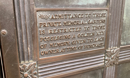 [Copper door embossed with the
words "Admittance to these private memorial gardens is restricted to those
possessing a golden key of memory, given to each owner at time of
purchase."]
