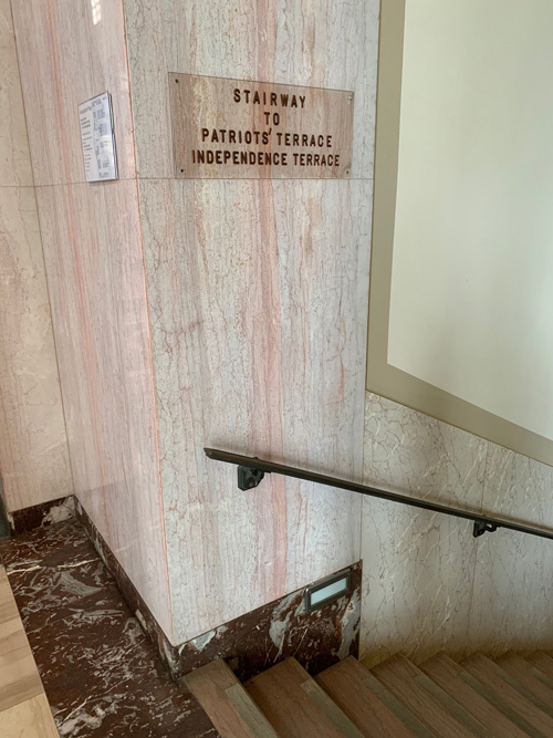 [Lettering on a clear sign
affixed to a marble-paneled wall at the top of a set of steps informs visitors
this is the "Stairway to Patriots Terrace."]