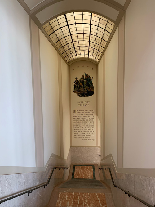 [View down the marble-covered
stairway to Patriots Terrace with a mural of a detail from the famous "Spirit of
76" painting by Archibald Willard and words attributed to William Tyler
Page.]