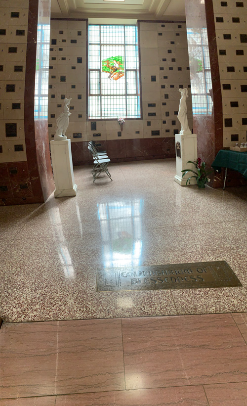 [Marble walls covered with
copper placards of various sizes marking the interment of ashes in the walls. A
brass placard cut with medieval-looking lettering set into the terrazzo floor
announces the "Columbarium of Blessedness."]
