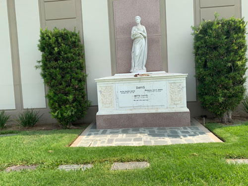 [Marble sarcophagus topped with
a marble statue of a standing robed figure; lettering spells out "Davis" and several
smaller names underneath.]