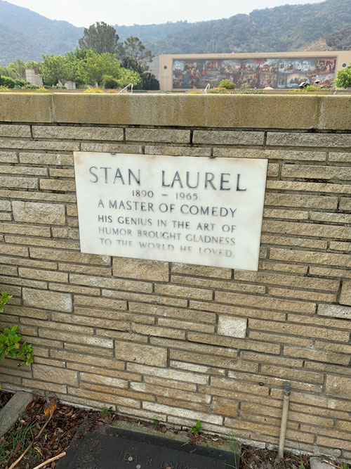 [Engraved stone set into a
brick wall announcing the grave of Stan Laurel, transcribed below.]