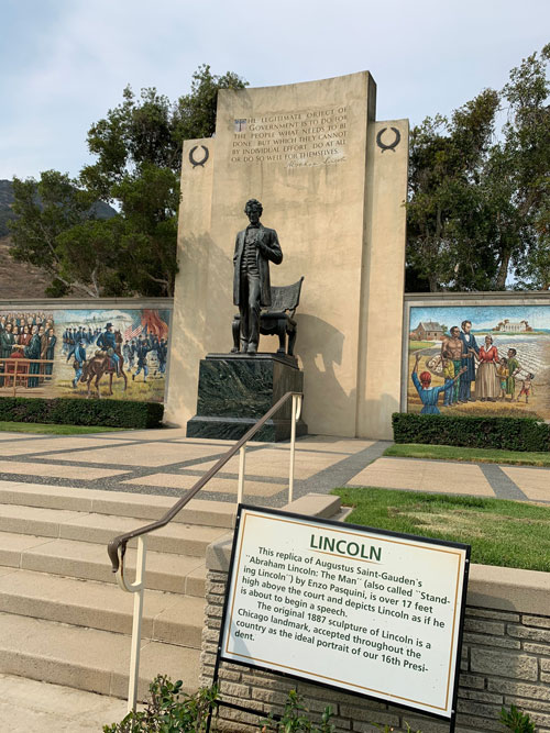 [Stairs leading up to a brozne
statue of Abraham Lincoln standing on a marble-covered pedestal, with
explanatory sign, transcribed below.]