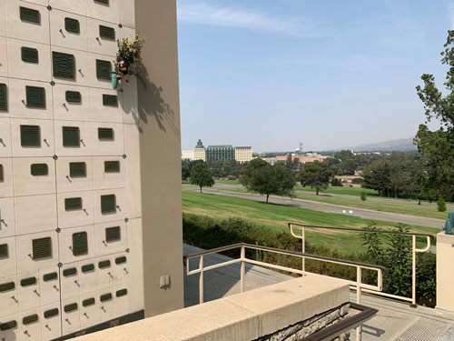 [A wall with many such metal
plaques; beyond a lawn that slopes downhill can be seen a cluster of buildings,
part of the Disney studio.]