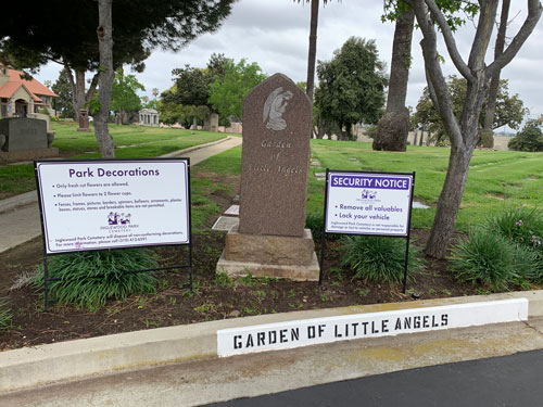 [Photograph of signs informing visitors about
grave decoration rules and reminding them to lock their cars above a curb
stenciled with the lettering "GARDEN OF LITTLE ANGELS."]