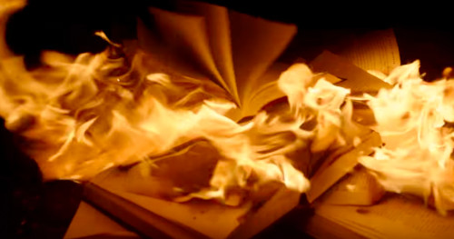 [Still from "The Unburnable
Book" video showing real books on fire.]