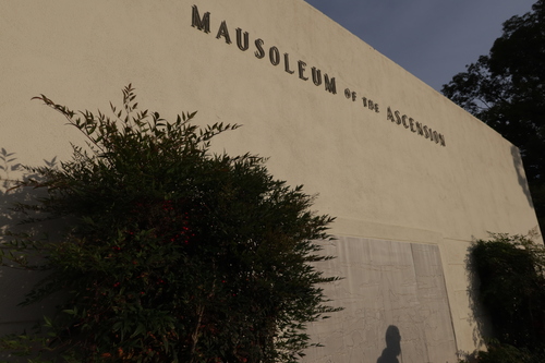 [Lawns full of copper grave
markers crossed by straight paths; in the distance, beyond a large, windowless
building, some hills of dirt leading up toward the darker chaparral of the Santa
Monica Mountains.]